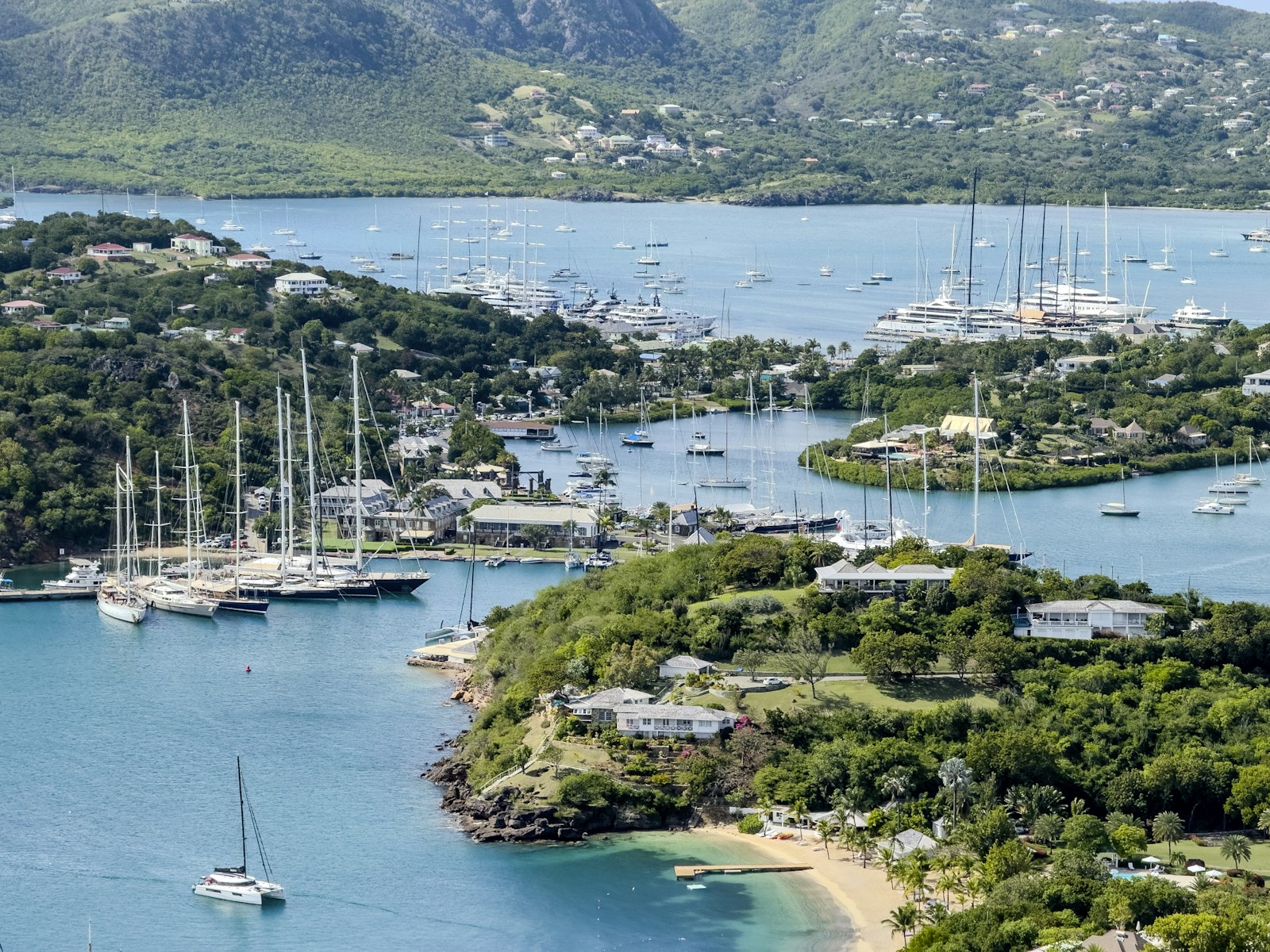 Yachts anchored in English Harbour, Antigua and Barbuda, with green hills behind the bay